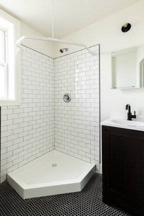 a white bathroom with a shower and a sink