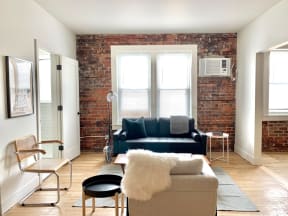 a living room with a couch and a brick wall