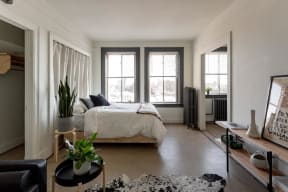 a bedroom with a bed and two windows