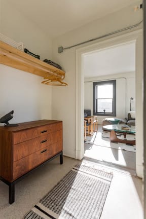 a living room with a dresser and a door into a room