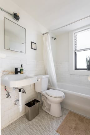 a bathroom with a toilet and a sink and a bath tub