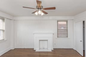 a living room with a fireplace and a ceiling fan