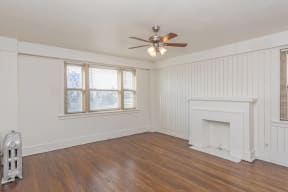 a living room with a fireplace and a ceiling fan