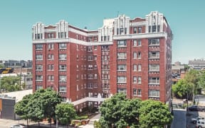 an aerial view of a large brick building with trees in front of it