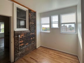 a living room with a brick wall and a wood floor