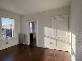 a living room with a wood floor and a door to a hallway