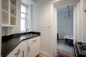 a small kitchen with a sink and a door to a bathroom