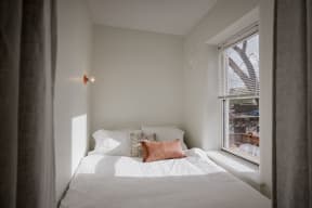 a small bedroom with a bed and a window