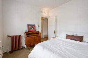 a bedroom with a bed and a dresser     and a door