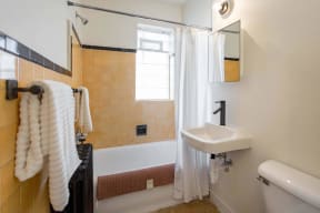 a bathroom with a tub and a sink and a window