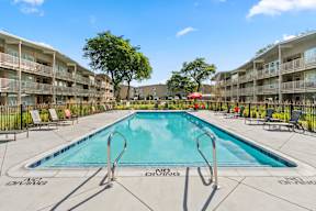 A swimming pool in a residential area with a sunny sky.