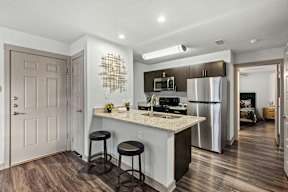 A kitchen with a bar stool and a counter.