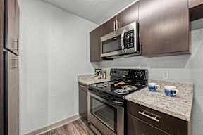 A modern kitchen with a stainless steel oven and microwave.