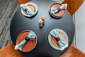 a table with two plates and two napkins on it with blue and orange plates