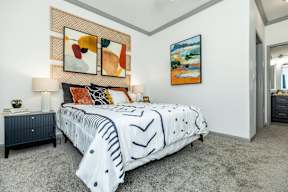 a bedroom with a bed and paintings on the wall