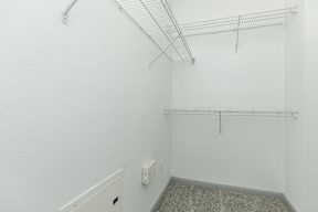 an empty room with white walls and a white urinal in the corner