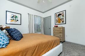 a bedroom with a bed and pictures on the wall