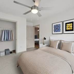 A bedroom with a large bed and a ceiling fan.