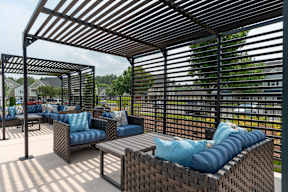 A patio with a black metal frame and blue cushions.