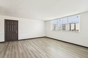 A room with a brown door and a window with blinds.