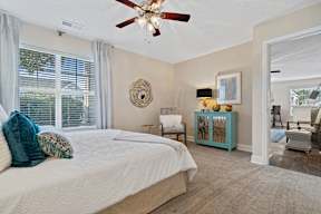 A bedroom with a large bed and a ceiling fan.