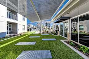 A yoga mat is placed on a green lawn.