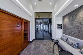 A hallway with a wooden door and a white sofa.