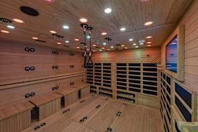 A sauna with wooden benches and a heater.