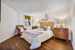 A bedroom with a bed, nightstand, and lamp.