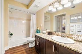 A bathroom with a white toilet and a white bathtub.
