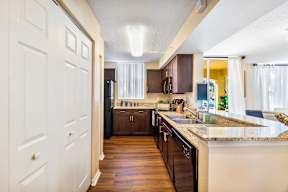 A kitchen with brown cabinets and a white door.