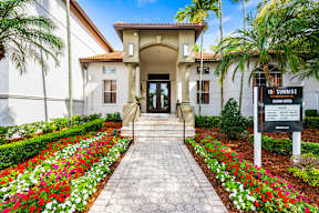 The image shows a beautiful entrance to a building with a sign that reads "10 SUNRISE".