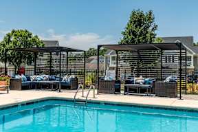 A pool with a black fence and a black umbrella.