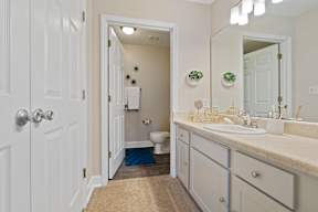 A bathroom with a toilet, sink, and mirror.