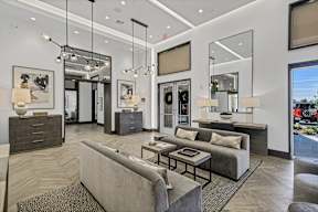 A modern living room with a grey sofa and a glass coffee table.