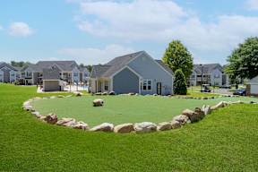 A residential area with houses and a well-maintained lawn.