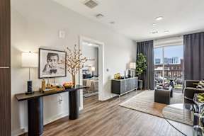 A modern living room with a black and white framed picture on the wall.