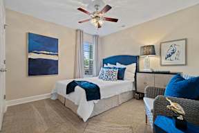 A bedroom with a large bed and a painting on the wall.