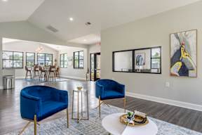 A living room with blue chairs and a white table.