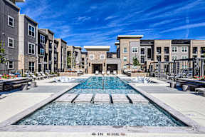 A pool surrounded by buildings with a no diving sign.