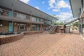 a brick courtyard with a staircase in front of a building