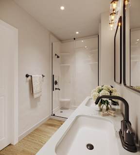 A white sink in a modern bathroom with a glass shower door.