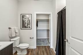 A bathroom with a toilet, a sink, and a picture on the wall.