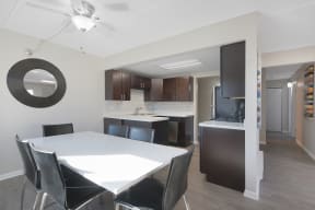 a kitchen and dining room with a white table and black chairs