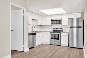 a kitchen with white cabinets and stainless steel appliances