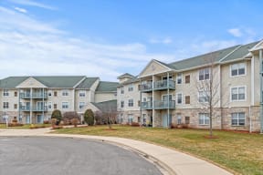 the view of an apartment building with a road in front of it