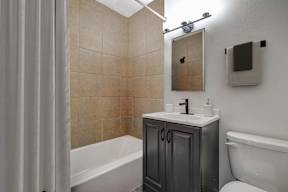 a bathroom with a shower and a sink and a toilet