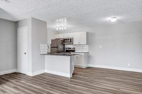 an open kitchen with an island and stainless steel appliances