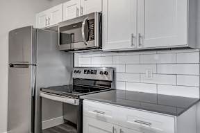 a kitchen with white cabinets and stainless steel appliances