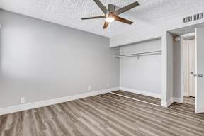 a bedroom with a ceiling fan and a closet